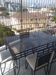 y balcón con mesa de cristal y sillas. en Rooms By the Pool, en Kingston