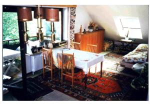 ein Wohnzimmer mit einem Tisch, Stühlen und einem Bett in der Unterkunft Ferienwohnung Vogesen in Badenweiler