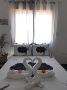 two swans making a heart on a bed at מתוק באמצע המדבר in Beʼer Ora