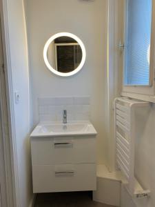 a white bathroom with a sink and a mirror at Le famillial , 2 chambres, 4 lits double Avec parking PRIVE 1 VOITURE, NETFLIX, DISNEY PLUS DISPONIBLE in Dieppe +30 photos