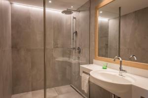 un bagno con doccia, lavandino e specchio di Hotel Gasthof Mostwastl a Salisburgo