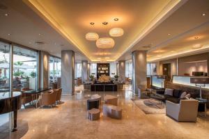 a lobby of a hotel with tables and chairs at Crowne Plaza Limassol by IHG in Limassol