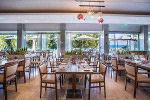 a dining room with tables and chairs and windows at Crowne Plaza Limassol by IHG in Limassol