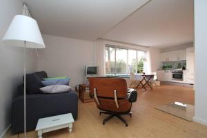 a living room with a couch and a chair and a table at Modern & Friendly Apartment Ammersee in Windach