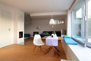 a kitchen and living room with a table and chairs at Modern & Friendly Apartment Ammersee in Windach