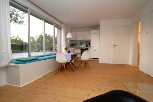 a kitchen and dining room with a table and chairs at Modern & Friendly Apartment Ammersee in Windach +8 photos
