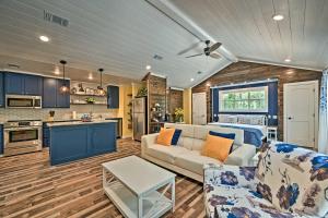 a living room with a couch and a kitchen at Modern Studio Cabin with Fire Pit, Deck, and BBQ! in Broken Bow