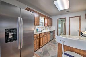 a kitchen with a stainless steel refrigerator and wooden cabinets at Lakefront Home Less Than 3 Miles to Historic Granbury! in Granbury