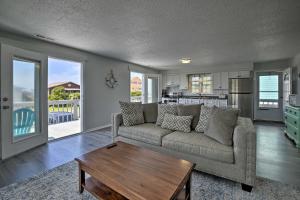 a living room with a couch and a table at Oak Island Beach Abode with Deck Walk to Shore! in Oak Island