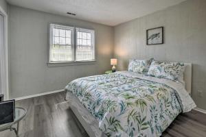 a bedroom with a bed and a window at Oak Island Beach Abode with Deck Walk to Shore! in Oak Island