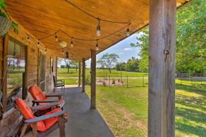 eine Veranda eines Hauses mit orangefarbenen Stühlen darauf in der Unterkunft Texas Cabin on 130 Acres Walk to Lake Ray Roberts in Collinsville