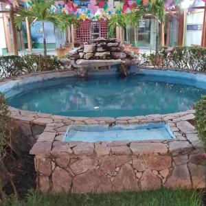 a large swimming pool with a stone wall around it at Apartamento Praia do Forte in Mata de Sao Joao