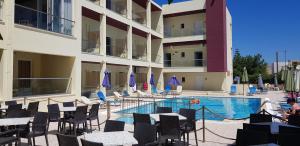 a hotel with a swimming pool in front of a building at Alexandros Hotel in Sisi