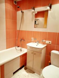 a bathroom with a sink and a toilet and a mirror at Klaipėda Apartament in Klaipėda