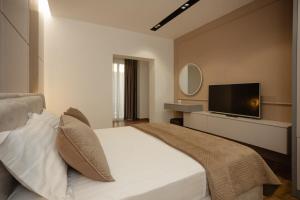 a bedroom with a large bed and a flat screen tv at KOMPLEKSI ROYAL in Velipojë