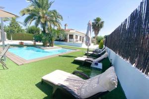 a pool with chaise lounge chairs next to a house at Relax en la huerta de Murcia in Murcia