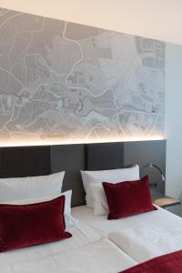 um quarto com uma cama com almofadas vermelhas e um mural em FischerS - Kurparkhotel Bad Wilhelmshöhe em Kassel