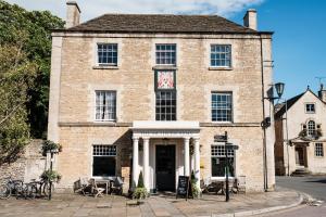 um velho edifício de tijolos com um relógio em The Methuen Arms em Corsham