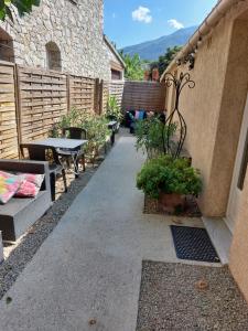 un patio con una mesa, bancos y una valla en Casa Petra, en Corte