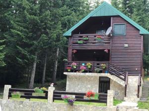 a log cabin with flowers on the balcony at Tanjuška in Žabljak