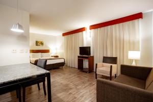 um quarto de hotel com uma cama e um sofá em Bourbon Ponta Grossa Convention Hotel em Ponta Grossa