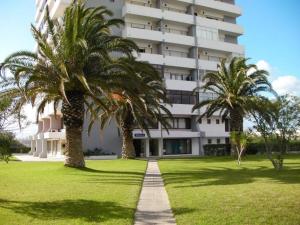 a building with palm trees in front of it at Sol e Praia Alvor 1 in Alvor