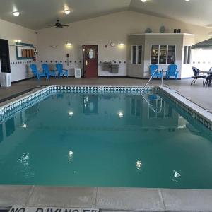 a swimming pool with blue chairs in a house at Osceola Grand Hotel in Evart