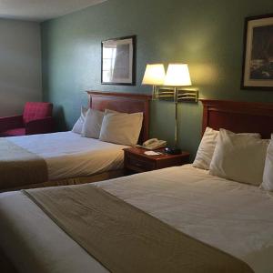 a hotel room with two beds and a phone at Osceola Grand Hotel in Evart