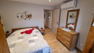 a bedroom with a bed and a dresser and a mirror at Appartement duplex climatisé avec terrasse "HANSI" in Colmar