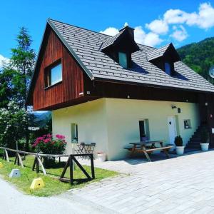 a house with a gambrel roof and a picnic table at Apartments Podkoren 82 in Kranjska Gora
