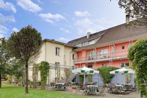 un hotel con mesas y sombrillas en un patio en Hotel Villa Martino - zum Hirsch en Bad Säckingen