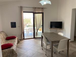 ein Wohnzimmer mit einem Tisch und einem Sofa in der Unterkunft Le Villette di Budoni e dintorni in Budoni