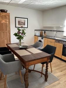 een keuken met een houten tafel met stoelen en een tafel bij Alte Gießerei in Ziesendorf