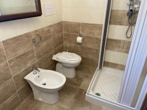 ein Bad mit einem WC, einem Waschbecken und einer Dusche in der Unterkunft Le Villette di Budoni e dintorni in Budoni