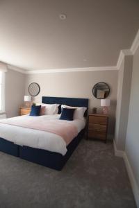 a bedroom with a large bed and two mirrors at 10 Bootham House - luxury city centre apartment with free parking for one car in York
