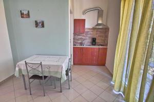 a kitchen with a table and a kitchen with a table and chairs at Plumeria Flowery in Agios Kirykos