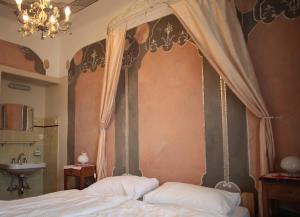 a bedroom with a canopy bed and a sink at Bed and Breakfast Casa Locarno in Locarno