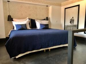 a bedroom with a large bed with blue sheets and pillows at Riad Dar Bahi in Marrakesh +30 photos