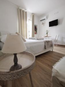 Sannicandro di BariにあるLike At Home B&Bのベッドルーム1室(ベッド1台、ランプ付きテーブル付)