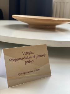 a sign sitting on top of a table with a plate at Apartmány LUXOR in Česká Lípa