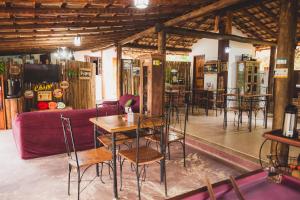 a restaurant with tables and chairs and a purple couch at Peniel do Sana Guest House in Sana