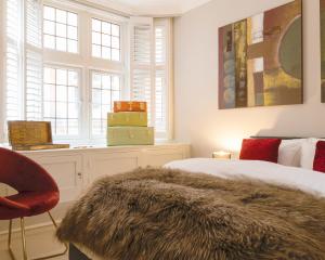 ロンドンにあるDiscover the Exclusive Charm of Covent Garden at a Luxury Nomads Homeのベッドルーム1室(ベッド1台、椅子、窓付)