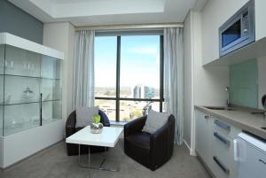 una cocina con 2 sillas y una mesa en una habitación en Sandton Skye Exclusive Apartment, en Johannesburgo