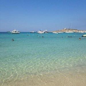 a beach with a group of people in the water at Hotel VIU57 in Mellieħa