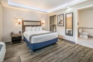 um quarto de hotel com uma cama e um WC em Inn at 50 - Long Beach Convention Center em Long Beach