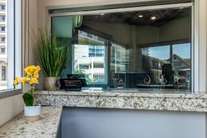 una ventana con un jarrón de flores en un mostrador en Inn at 50 - Long Beach Convention Center, en Long Beach