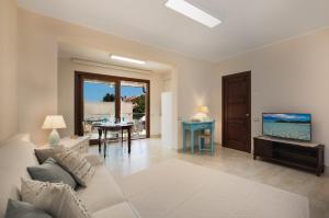 sala de estar con sofá y TV en relaxing holiday in Sardinia - Matafaluga apartment, en Capitana
