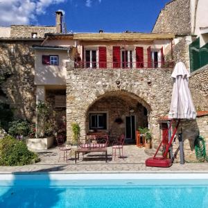 a house with a pool in front of a building at La Dolce Vita - Chambre Cristoforo Colombo in Montpeyroux