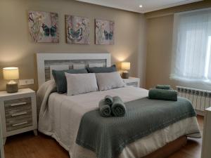 a bedroom with a bed with two towels on it at EL CAPRICHO - LUJO Y CONFORT EN EL CENTRO con PARKING INCLUIDO in Gijón