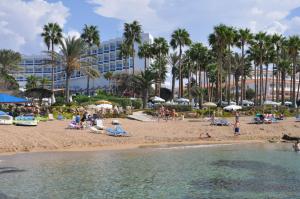 pessoas na praia em um resort com palmeiras em Leonardo Cypria Bay em Pafos